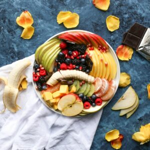 bowl of sliced fruits on white textile